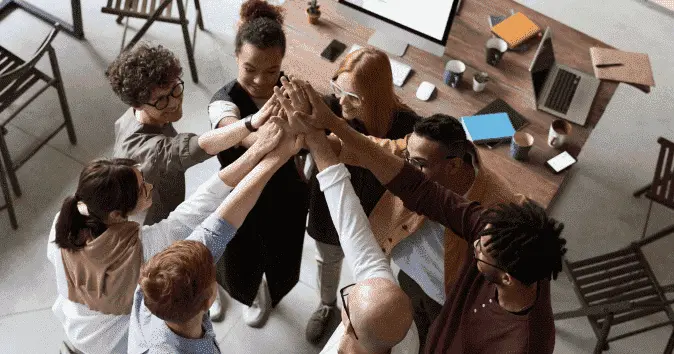 Group-high-five-of-a-diverse-team-of-employees-in-an-office