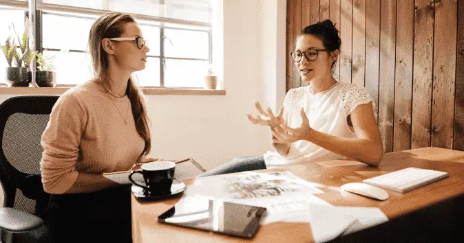 Young-female-HR-professionals-discussing-in-an-office-min