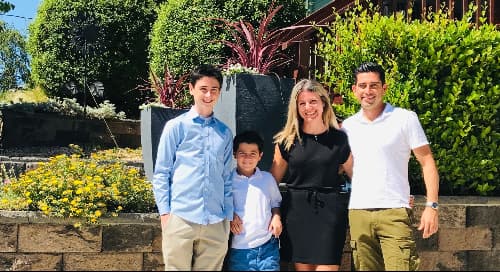 a family photo of two boys, a man and woman outside