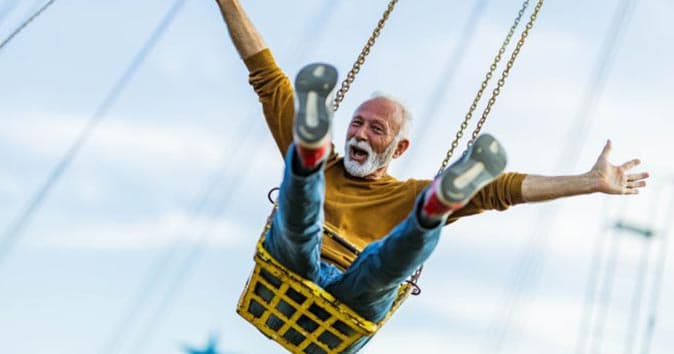 Happy older man on a carnival ride
