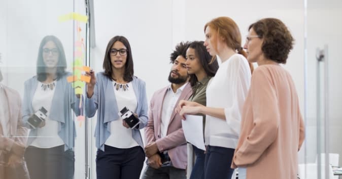 Group of people talking at a white board.