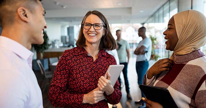 A group of people is happily smiling and engaging in a lively discussion.