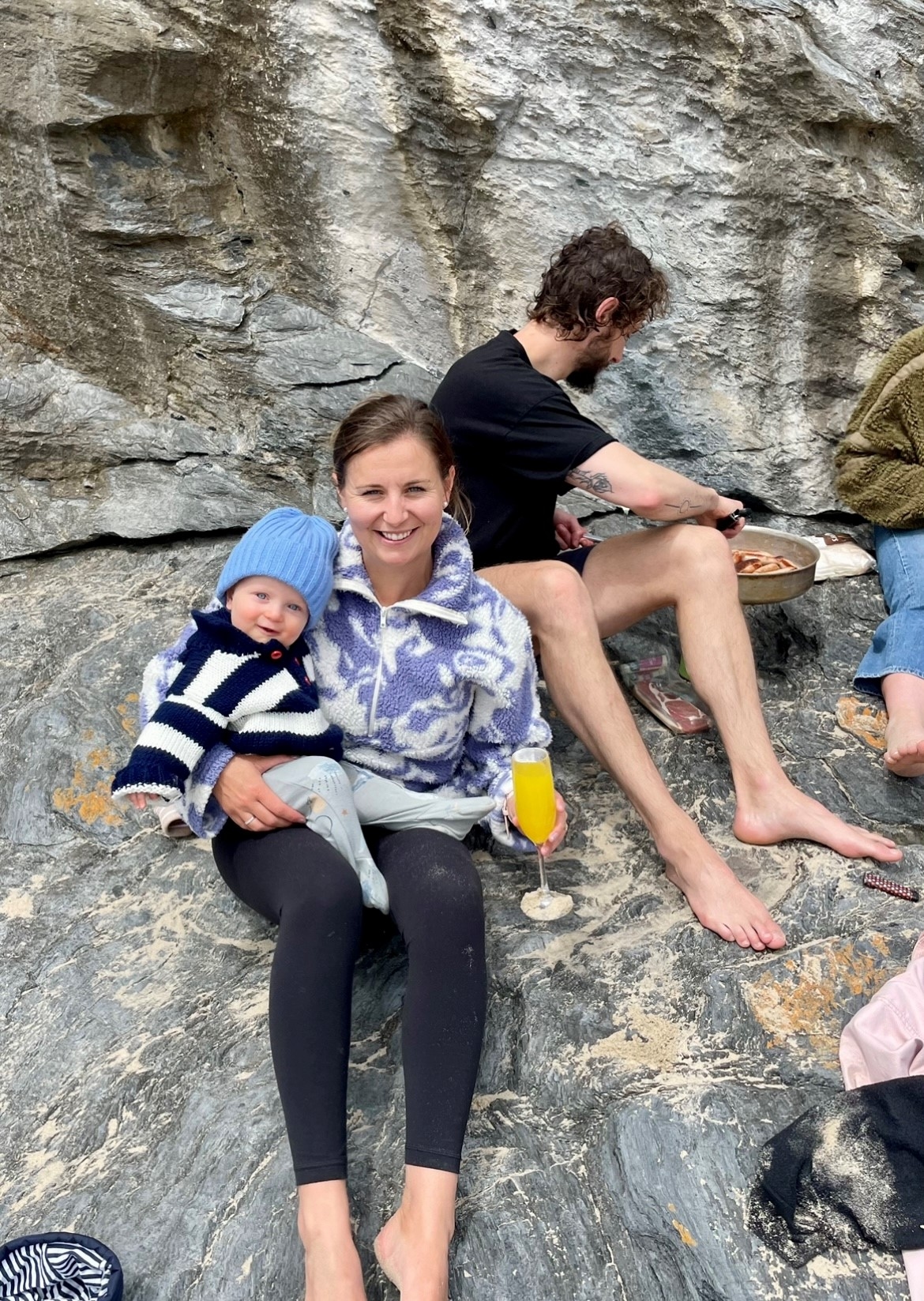 Emma and baby sitting outside on rocks