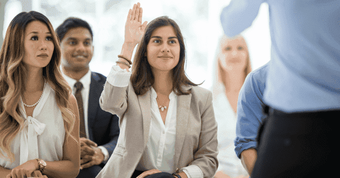 A female employee asking a question during a training and mentorship program