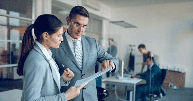 A senior mentor giving formal reviews to a young female employee because managers need a periodic review period