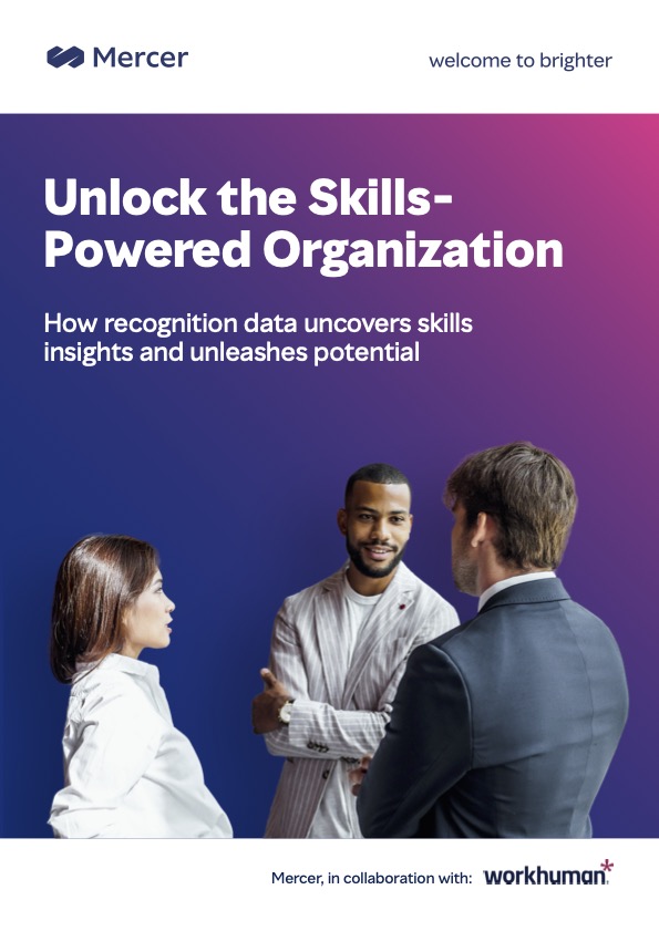 A digital brochure cover from Mercer titled "Unlock the Skills-Powered Organization." The design features a gradient background with three individuals in conversation: a woman with long hair dressed in a white blouse, a man with a striped jacket smiling, and another man in a suit facing the other two. The text highlights how recognition data can uncover skills insights and unleash potential, with a note that the collaboration is with Workhuman.