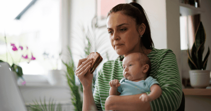 mom eating with baby while working