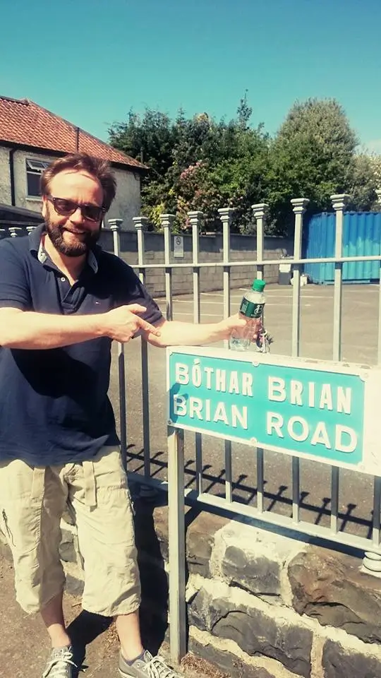 Brian by a sign that reads, "Brian Road"