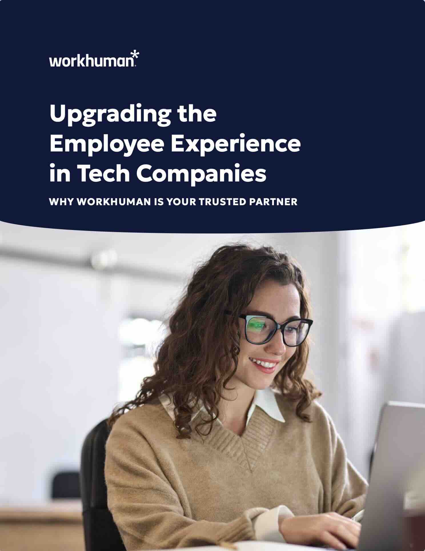 A woman with curly hair, wearing glasses, is smiling while engaged with a laptop. The background features a bright workspace. Above her, a text overlay reads "Upgrading the Employee Experience in Tech Companies," accompanied by the Workhuman logo. The subtitle states, "WHY WORKHUMAN IS YOUR TRUSTED PARTNER."