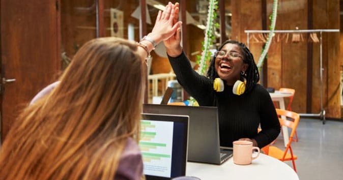 two coworkers high-fiving