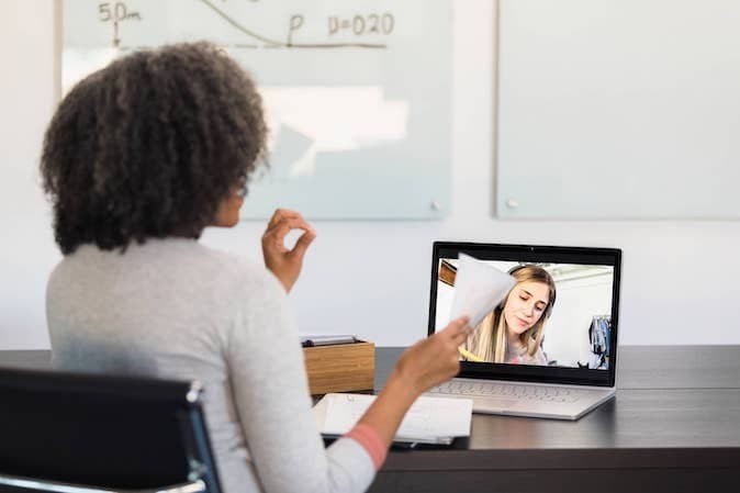 Two females attending a video call on the laptop