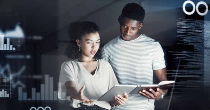 Two people looking at notes with digital information all around them.