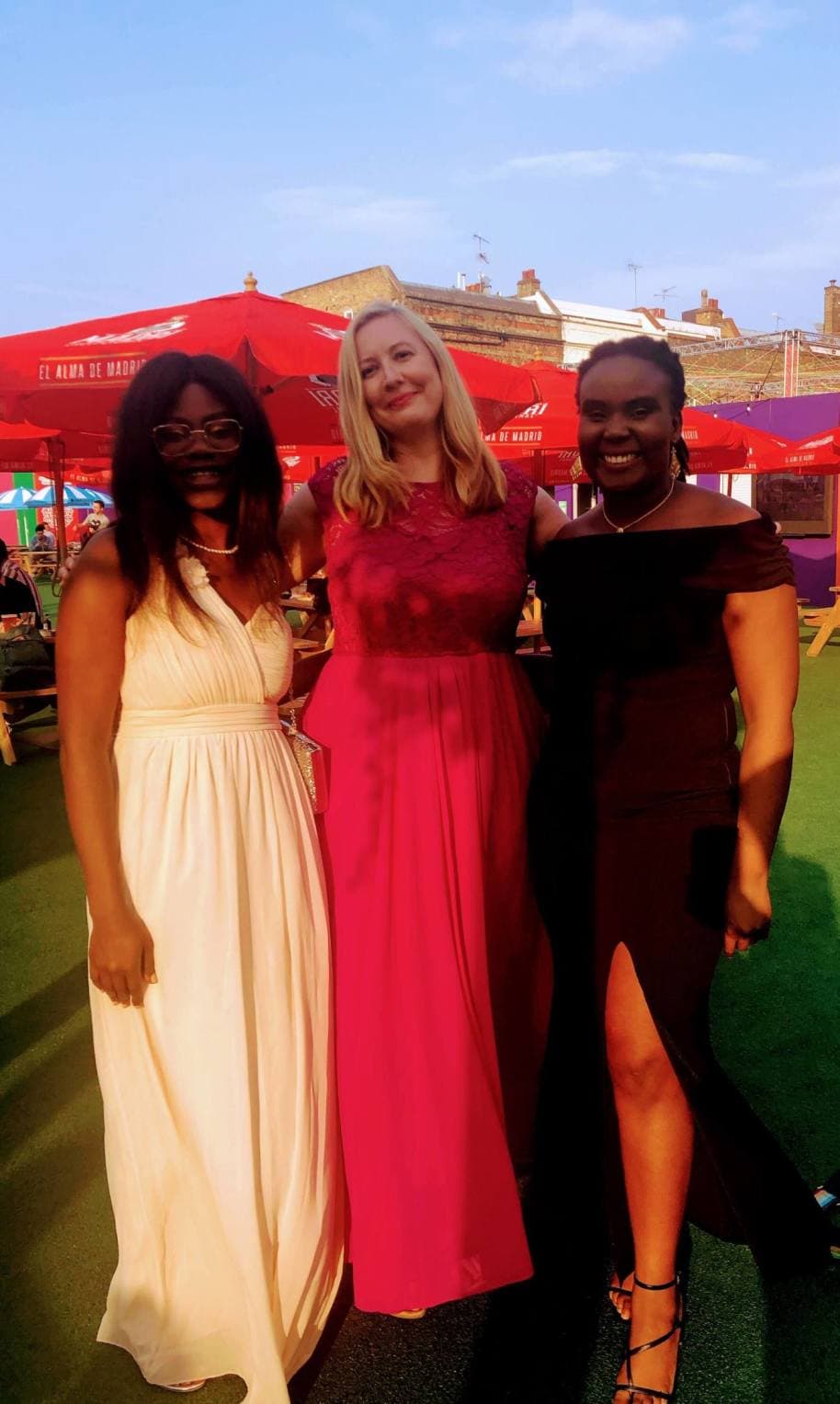 Alma posing with two other women in formal dresses