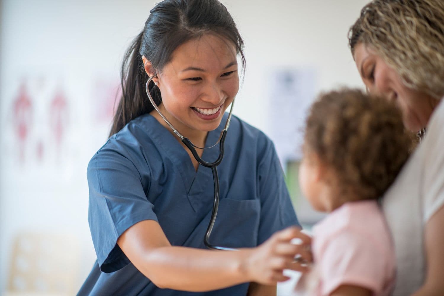Nurse in blue scrubs with kids