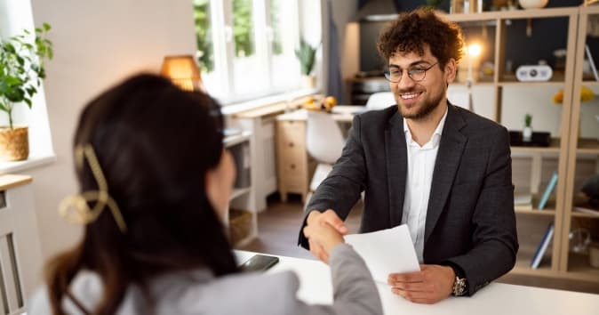 Two people in an office shaking hands.