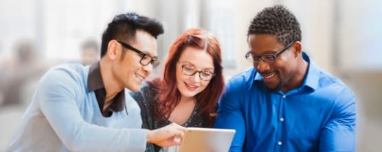 Three people looking at a tablet, discussing equity in the workplace.