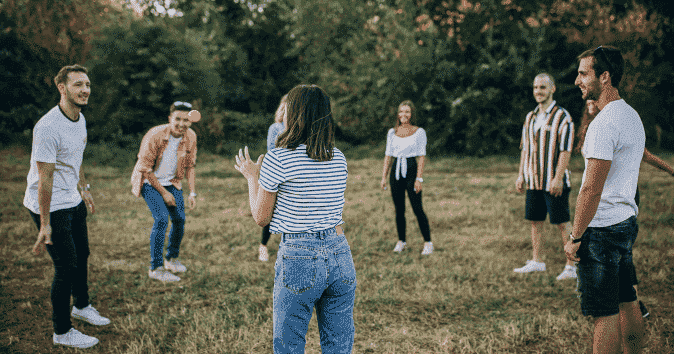 Large group of employees playing games on a team building seminar outdoors