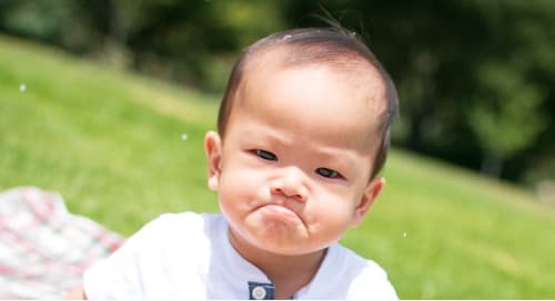photo of a baby with an exaggerated frown