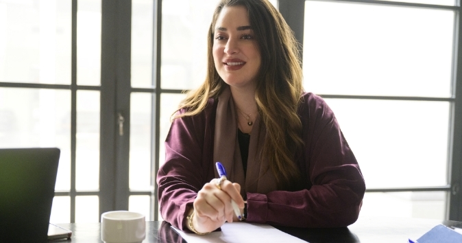 An employee engaged in office housework tasks with a positive attitude.