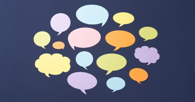 A collection of colorful speech bubbles in various shapes and sizes arranged on a dark background, meant to represent thank you messages and words of appreciation to employees.