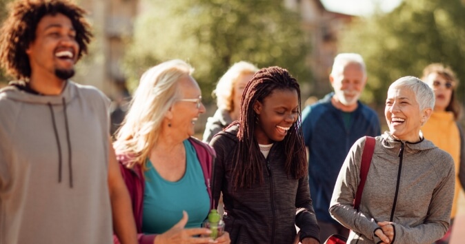 Group of diverse people laughing and walking.