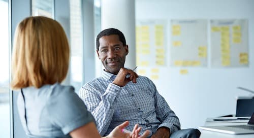 two colleagues discussing their employee experience in the office