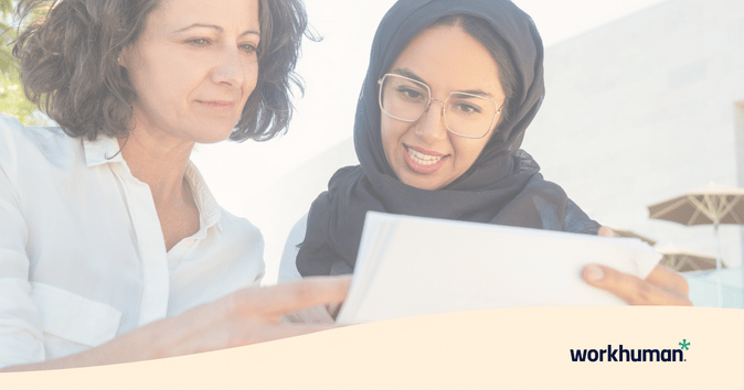 Two women reviewing a document with check-in questions together.