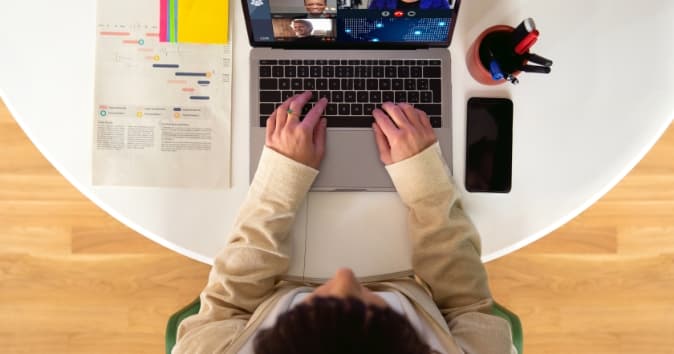 Above photo of a woman at a laptop on desk.