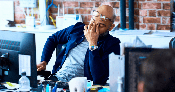 man exhausted at desk