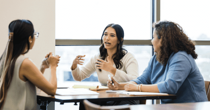 A human resource manager talking to two female employees